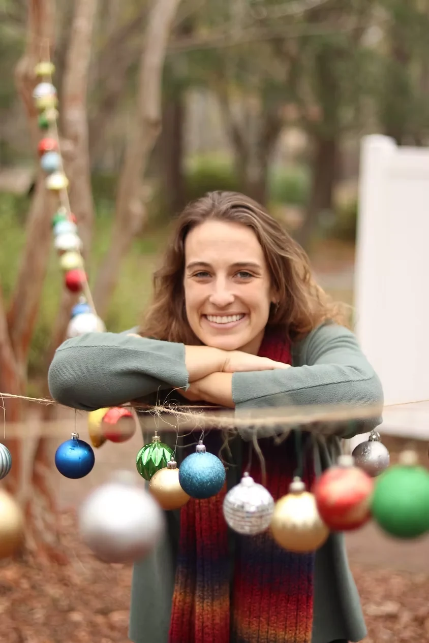 Allie smiling outside under warm string lights