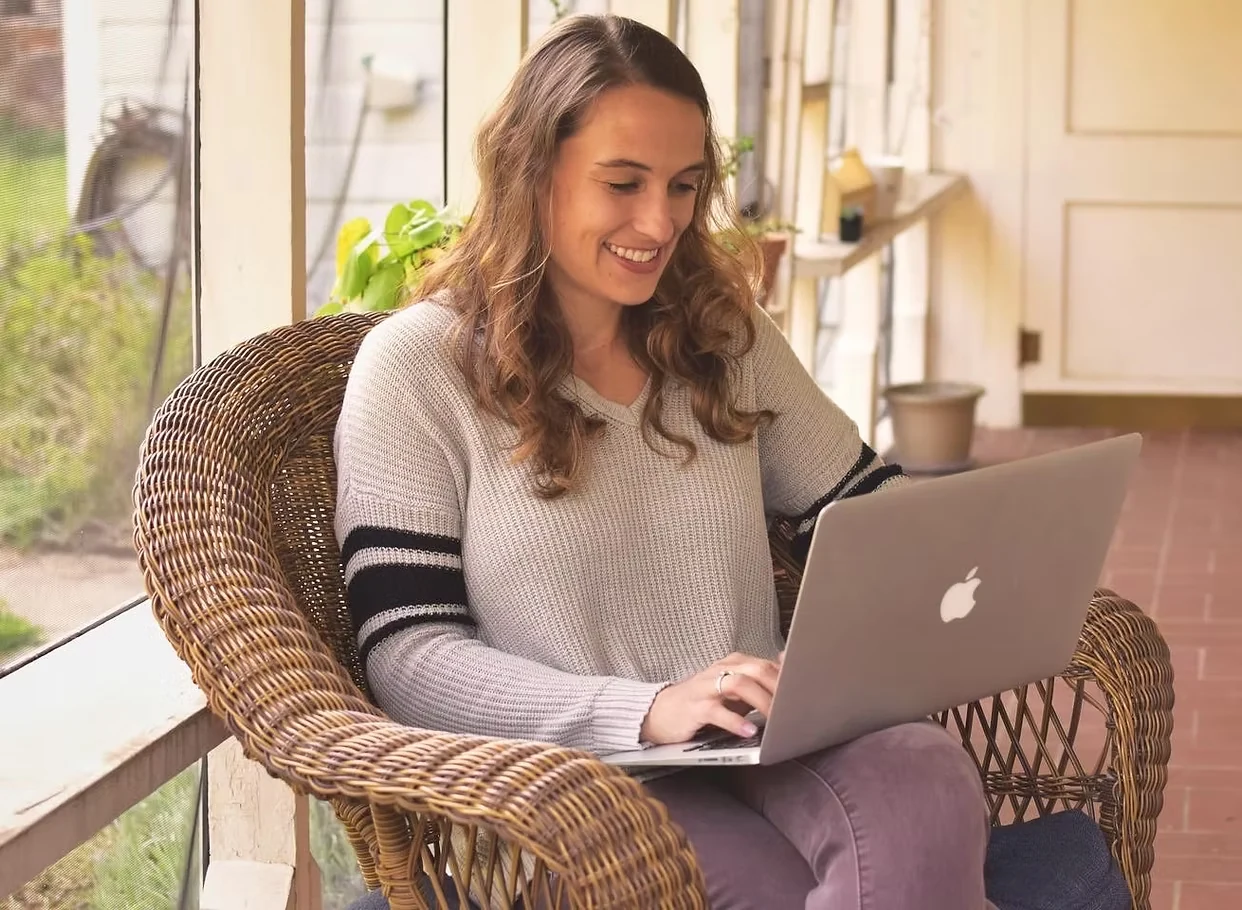 Allie smiling while working on her laptop