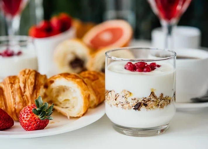 A balanced breakfast with yogurt, oats, berries, and a croissant
